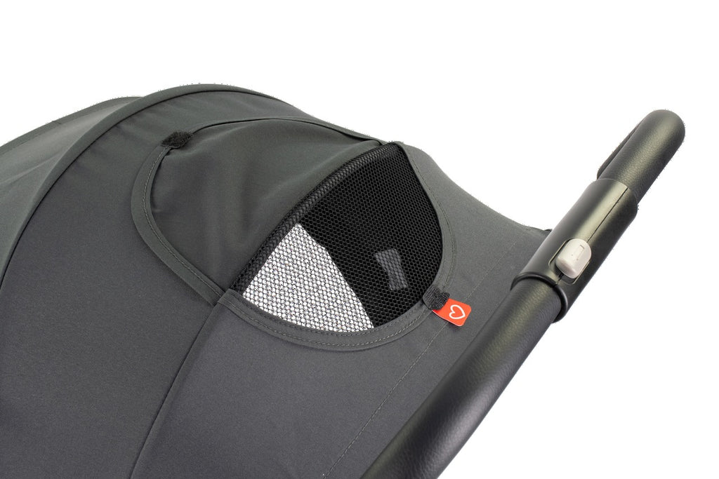 Close-up of a gray stroller with a mesh window and handle on a white background